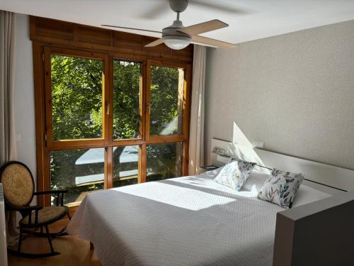 a bedroom with a bed with a ceiling fan and a window at Las Estrellas de Soria in Soria