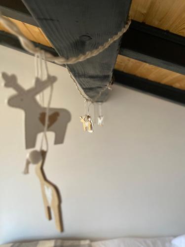 a shadow of a cross and a toy deer hanging from a ceiling at HUUT in Zlatibor