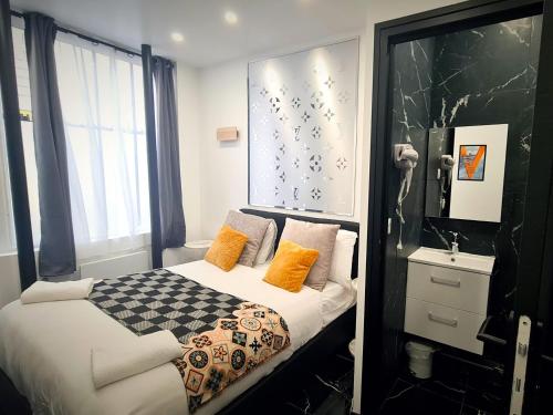 - une chambre avec un lit et une couverture à motifs en damier dans l'établissement Urban Flat 189 - Atelier Montparnasse Vuitton, à Paris