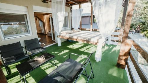 a room with a bed and chairs on a green floor at Vila Dunja 2 in Divčibare