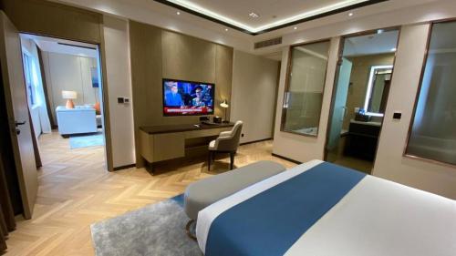 a bedroom with a bed and a desk and a television at Ocean Delight Boutique Hotel 海悦精品酒店 in Sihanoukville