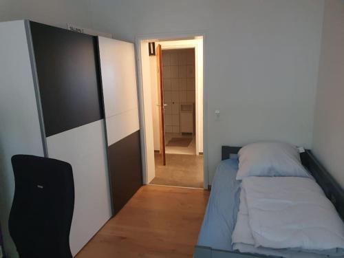 a small bedroom with a bed and a hallway at Gemütliche 3-Zimmer-Wohnung mit TG-Stellplatz - Top-Lage in Karlsruhe in Karlsruhe