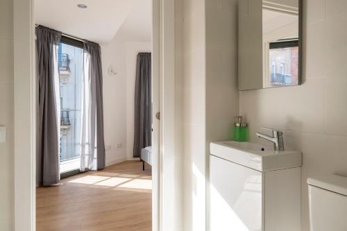 een witte badkamer met een wastafel en een spiegel bij Centric Apartment Camp Nou 2 in Hospitalet de Llobregat