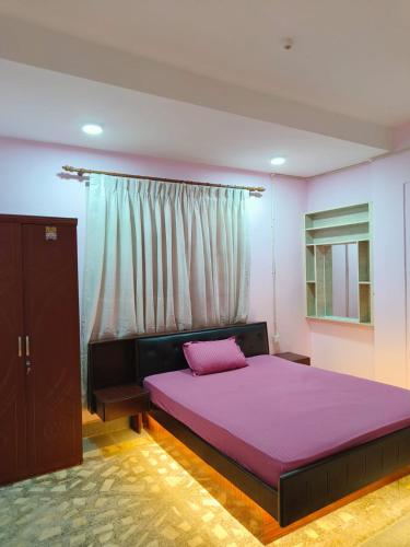 a bedroom with a purple bed with a window at Peakman Residence in Kathmandu