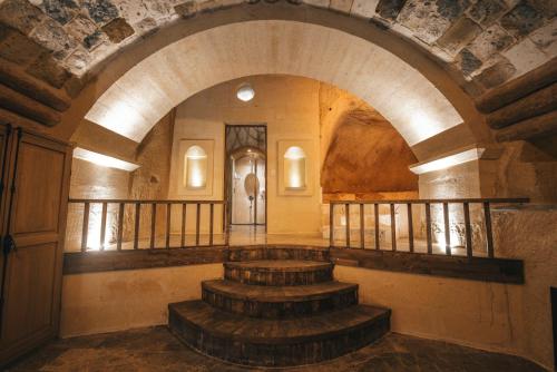 a hallway with stairs in a building with an archway at Harem Suites Cappadocia in Uchisar