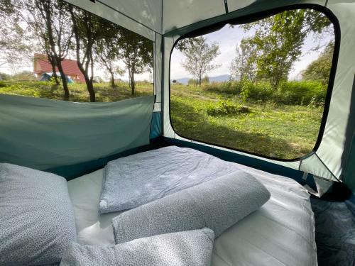 a bed in the back of a tent with a window at Camping Baleia in Pui
