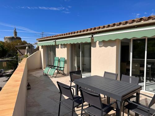 une table noire et des chaises sur une terrasse dans l'établissement Le batelier, à Aigues-Mortes