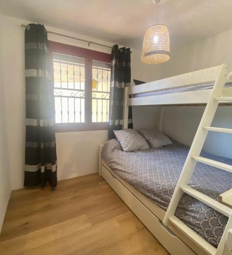 une chambre avec un lit superposé et une fenêtre dans l'établissement Appart 70m2 avec piscine, à Saint-Geniès-de-Varensal