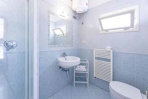 a bathroom with a sink and a toilet and a mirror at Camping Bungalow Lido in Capoliveri