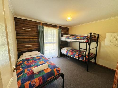 Postel nebo postele na pokoji v ubytování Halls Gap Log Cabins