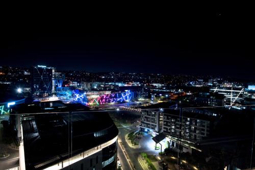 a view of a city at night with lights at The Capital Trilogy Menlyn Maine in Pretoria