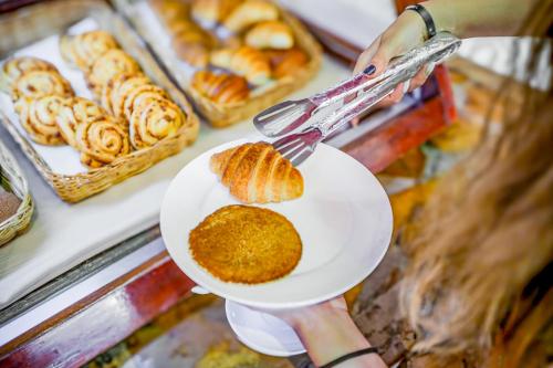 een persoon die een bord vasthoudt met daarop een gebakje bij AHG Waridi Beach Resort & SPA in Pwani Mchangani