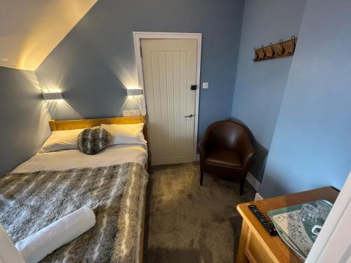 a small bedroom with a bed and a chair at Severn Valley Guest House in Bewdley