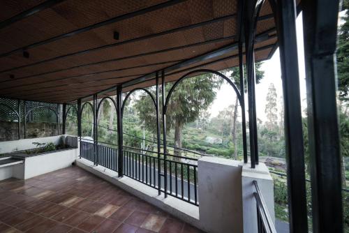 a building with a balcony with a view of trees at Akkandi Veedu in Kodaikānāl