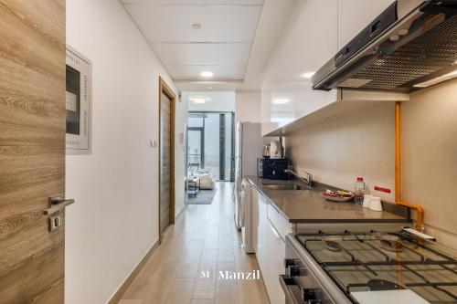 a kitchen with a stove and a counter top at Manzil - Stylish living in JVC, City Views and Pool in Dubai