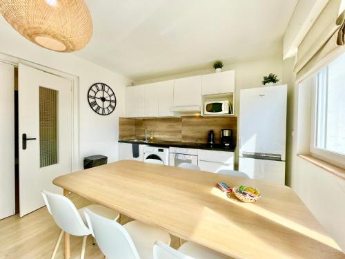 a kitchen and dining room with a wooden table and chairs at SMILE APPARTS - Appartements - Au coeur de Lorient - Au calme - Tout Confort in Lorient