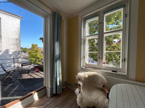a stuffed teddy bear sitting in a room with a window at Hel bylejlighed i det gamle pulsernede Svendborg in Svendborg