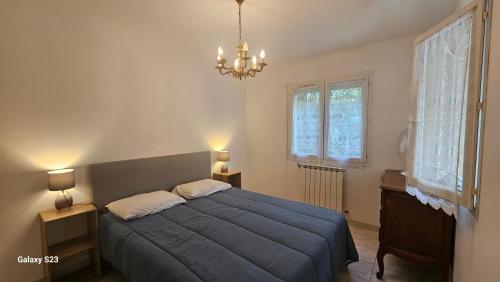 une chambre avec un lit bleu et deux fenêtres dans l'établissement Unique ! Montpellier proche centre Maison avec jardin, à Montpellier