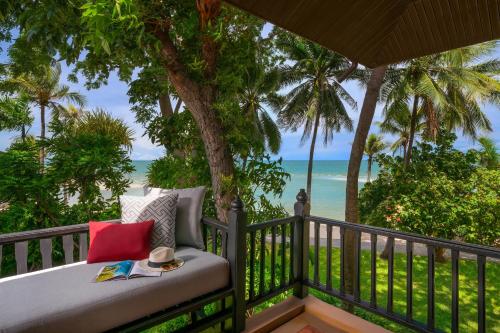 a bed on a balcony with a view of the beach at Anantara Hua Hin Resort in Hua Hin