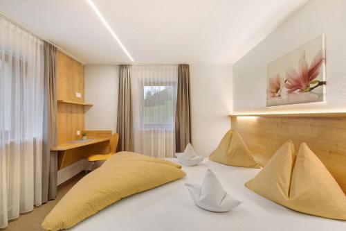 a room with a bed with pillows and a desk at Bed and Breakfast Ederhof in San Giacomo