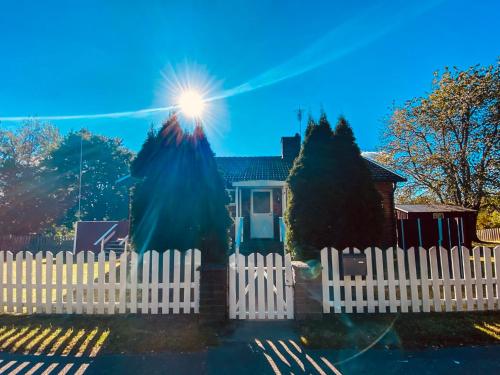 a white picket fence in front of a house at FoRest House in Rosenfors