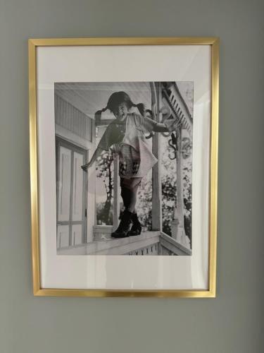 a framed picture of a woman standing on a porch at FoRest House in Rosenfors