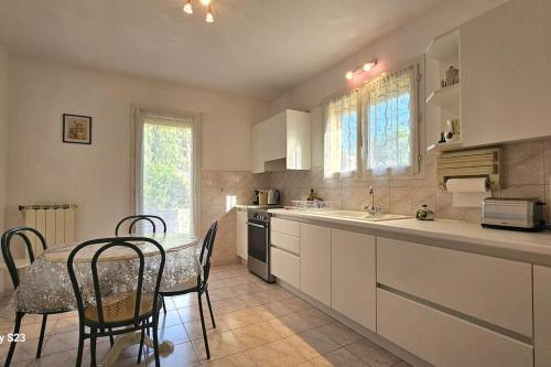 - une cuisine avec une table, des chaises et un comptoir dans l'établissement Unique ! Montpellier proche centre Maison avec jardin, à Montpellier