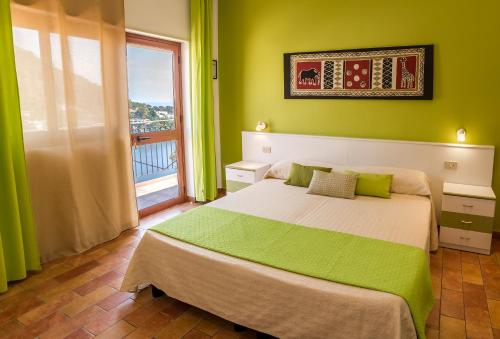 a green bedroom with a bed and a window at Le Terrazze sul mare in Ustica
