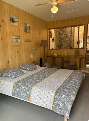 - 2 lits dans une chambre dotée de murs en bois dans l'établissement Le chalet du bonheur, à Gujan-Mestras