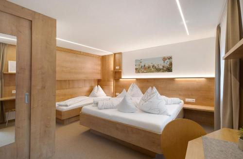 two beds in a hotel room with white pillows at Bed and Breakfast Ederhof in San Giacomo