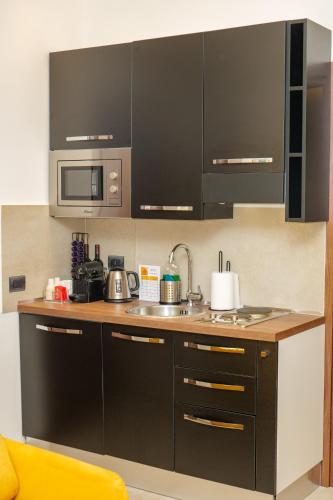 a kitchen with black cabinets and a microwave at Domus Aurelia in Rome