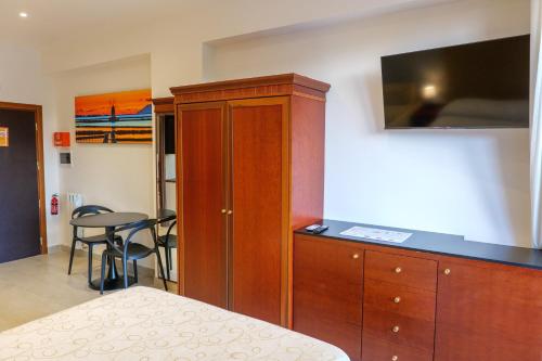 a bedroom with a wooden cabinet with a flat screen tv at Domus Aurelia in Rome