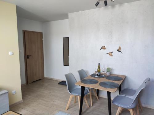 a dining room with a wooden table and chairs at Dwernikowe Wzgórze in Dwernik