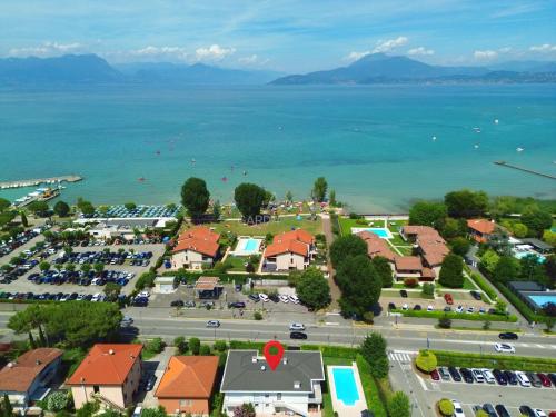 eine Luftaufnahme einer Stadt mit einem Parkplatz und dem Wasser in der Unterkunft Villa Marina - Risveglio Vista Lago con Piscina in San Martino della Battaglia