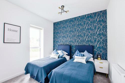 deux lits dans une chambre aux murs bleus dans l'établissement Homi Host-Apricot House, à Birmingham