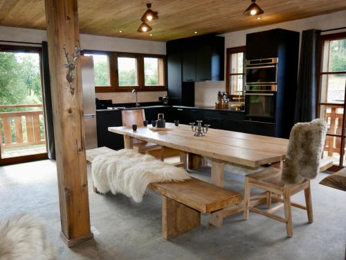 une grande cuisine avec une table en bois et un banc dans l'établissement Appartement Panthère, à Demi-Quartier