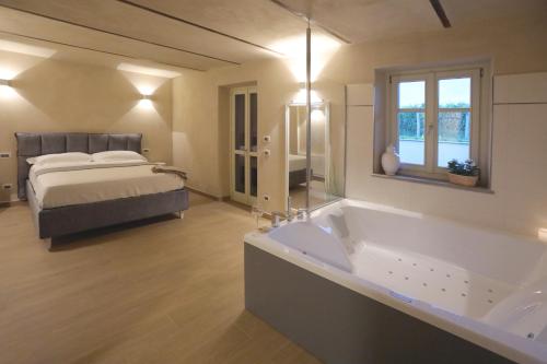 a large bathroom with a tub and a bed at Cascina Bricco San Pietro Bed & Wine in Monforte dʼAlba