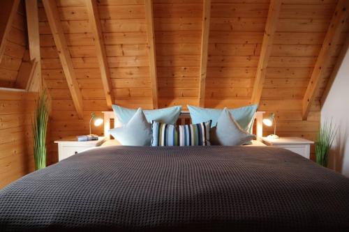 a bedroom with a large bed with wooden ceilings at Ferienhaus Zimmers-Nordseehaus in Dorum Neufeld