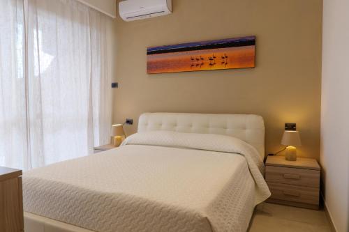 a bedroom with a white bed and a painting on the wall at Domus Aurelia in Rome