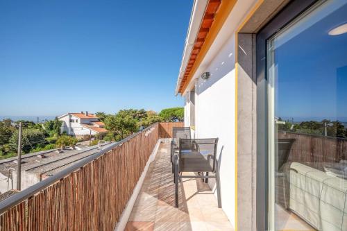 a balcony with a chair and a view of the ocean at One haven with stunning views in Alcabideche