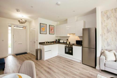 a kitchen with white cabinets and a stainless steel refrigerator at Homi Host-Apricot House in Birmingham
