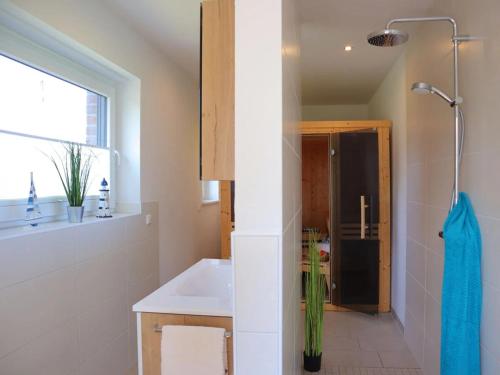 a bathroom with a sink and a shower at Ferienhaus Luv in Dorum Neufeld
