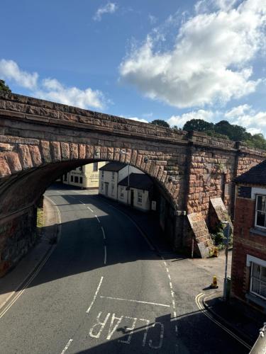 an old stone bridge over a street with a road at Severn Valley Guest House in Bewdley