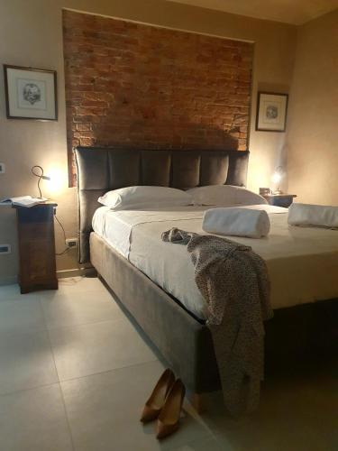 a bedroom with a large bed with a brick wall at Cascina Bricco San Pietro Bed & Wine in Monforte dʼAlba