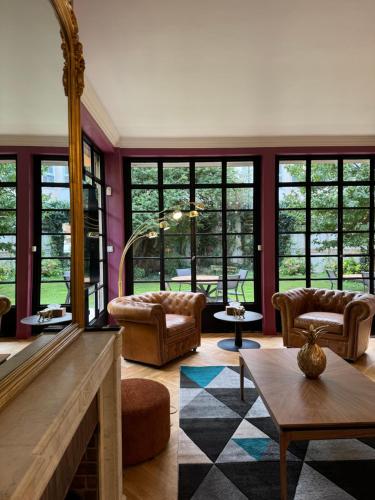 a living room with a fireplace and furniture and windows at Erawan Boutique Hôtel in Évreux