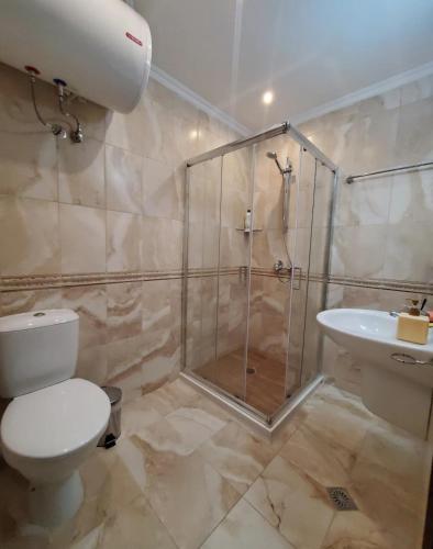 a bathroom with a shower and a toilet and a sink at Уютно студио до морето - апартаменти 25 и 26, топ локация - Cozy Studio by the Sea - Apartments 25 and 26 Top Location in Sveti Vlas