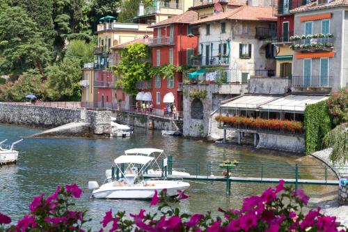 a boat is docked in a river with buildings at Parco dei Cervi Terrazzo in Plesio