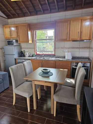 a kitchen with a wooden table and chairs and a table and a table and chairs at Casa da estrela sirius in Cabeço Chão