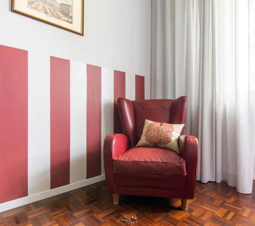 a red chair with a pillow in a room at Villa Fiori B&B in Moncalvo
