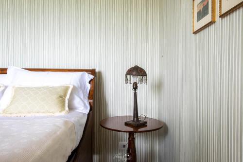 a bedroom with a bed and a table with a lamp at Villa Fiori B&B in Moncalvo